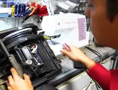 Vacuum repair technician servicing internal components on a workbench in Santa Ana, CA